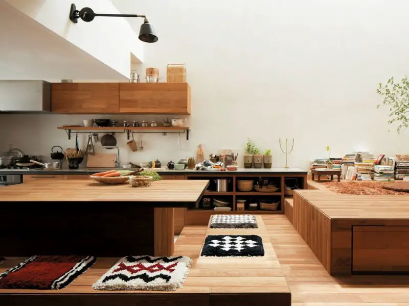 In the photo, the design of a Japanese kitchen with a low wooden table covered with pillows.